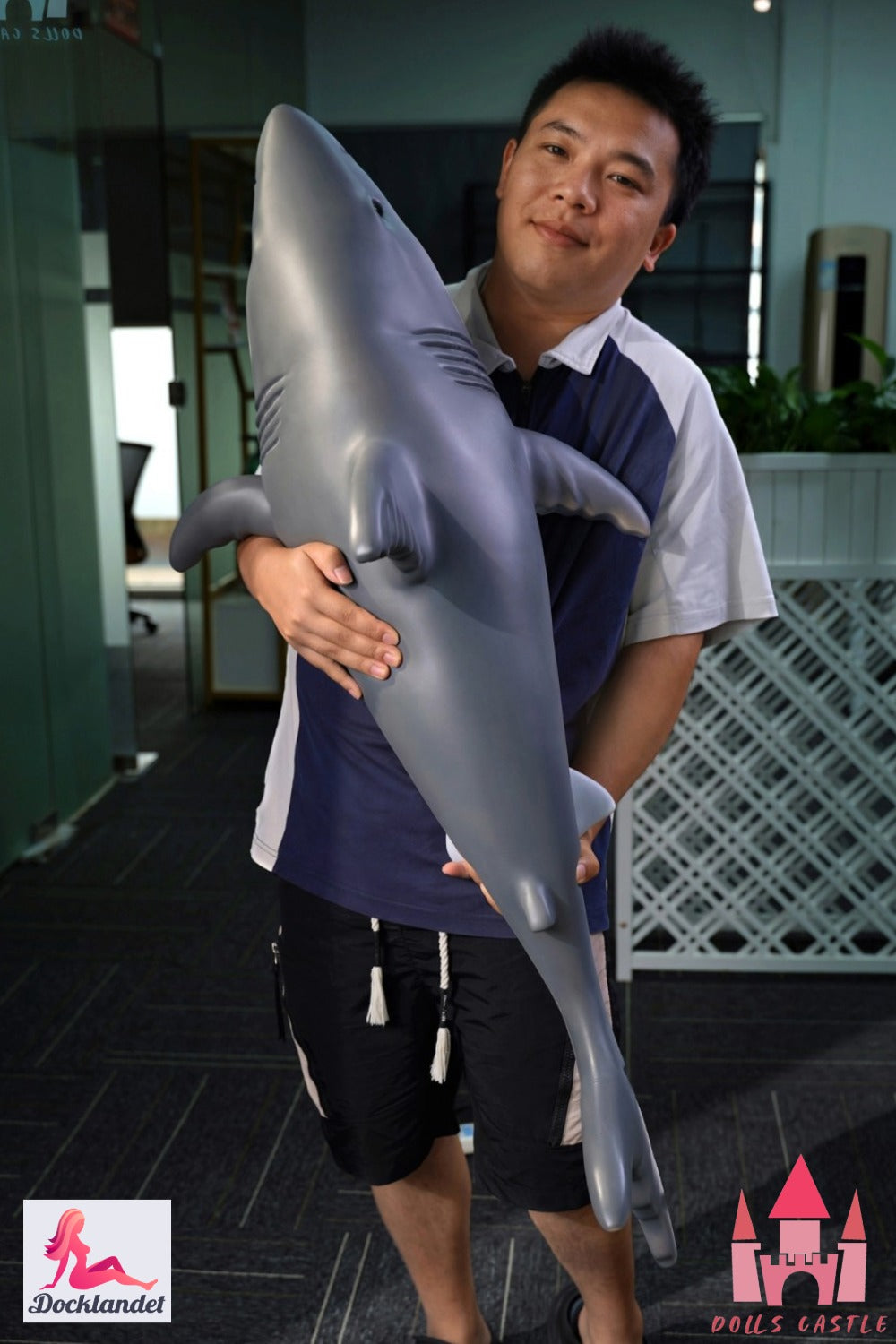Shark Doll 110 cm hålls i famnen för att visa storlek och proportioner, realistisk haj design med grå ovansida och vit undersida.