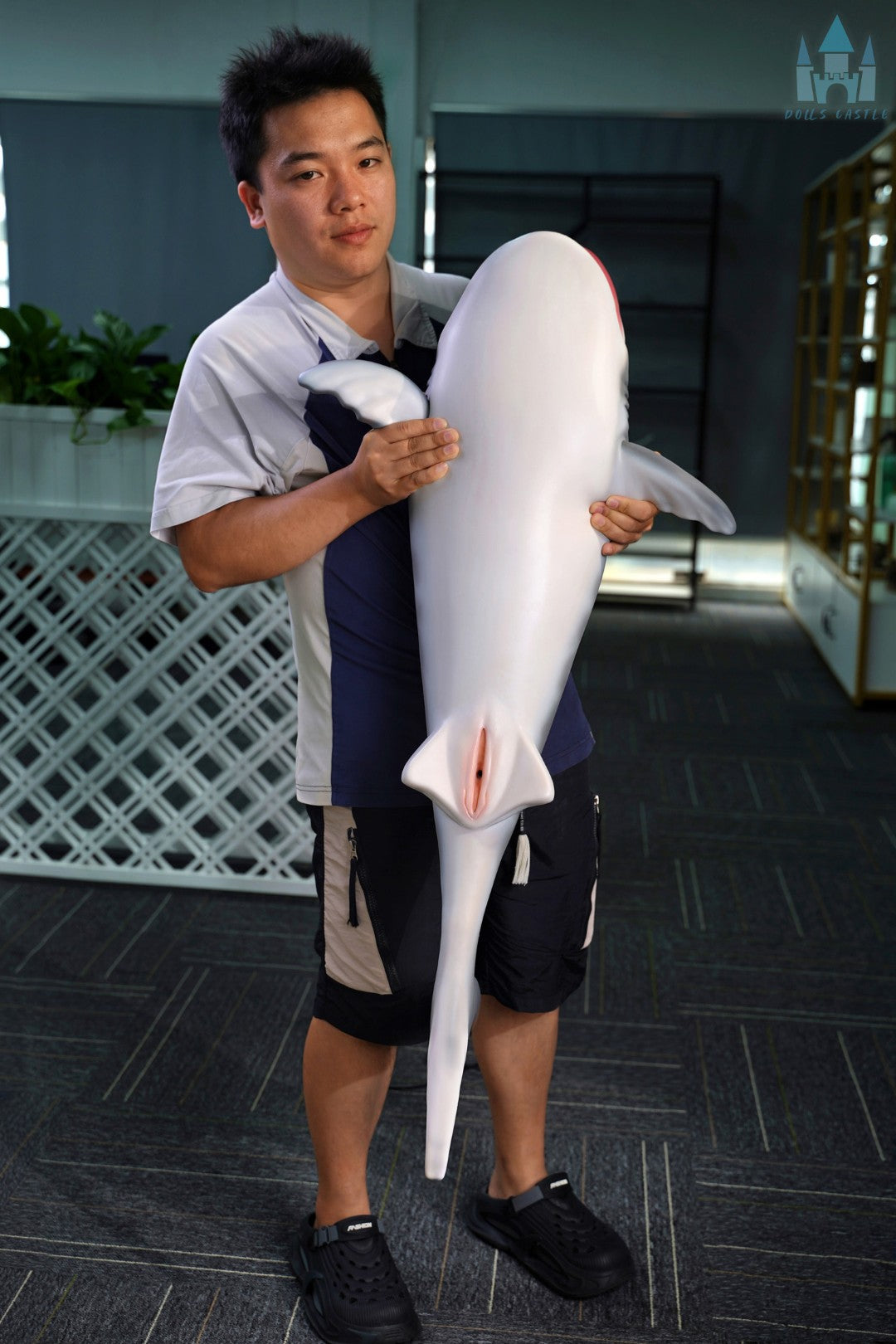 Shark Doll 110 cm hålls i famnen för att visa storlek och proportioner, realistisk haj design med grå ovansida och vit undersida.